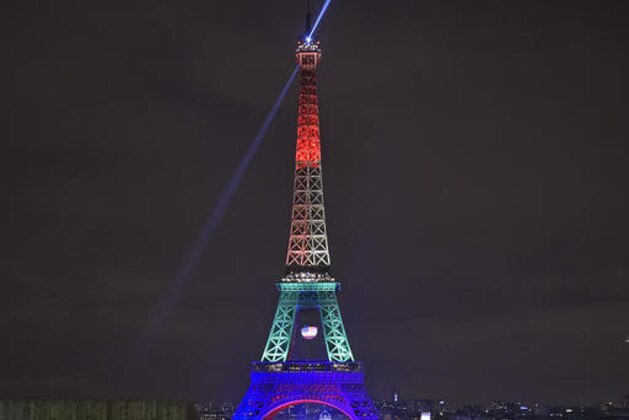 The Eiffel Tower in Paris, France, shines in the colors of a rainbow to honor victims of Sunday's mass shooting at an Orlando gay club, Monday, June 13, 2016. People brought banners, flags and candles to the Place Trocadero in front of the Paris landmark. (AP Photo/Martin Meissner)