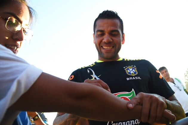 Brazilian national team player Dani Alves signs a fan's arm after a training session June 2, 2016 at the University of California, Los Angeles (UCLA) in preparation for the Copa America 2016, in Los Angeles. / AFP / ROBYN BECK        (Photo credit should read ROBYN BECK/AFP/Getty Images)