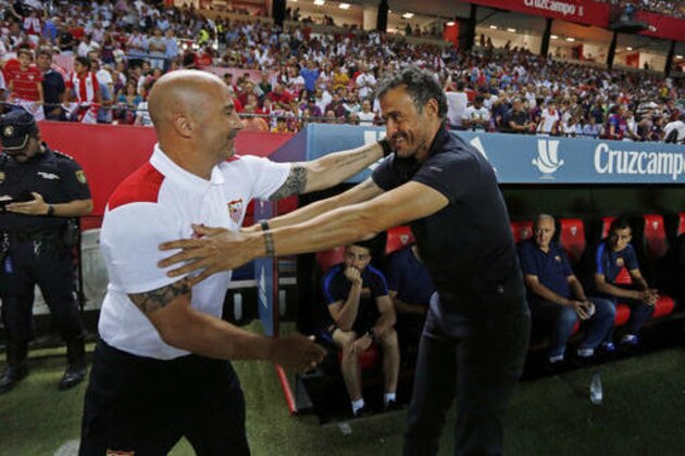 Sevilla coach Jorge Sampaoli, left, and Barcelona coach Luis Enrique greet each other before a Spanish Super Cup first-leg soccer at Ramon Sanchez-Pizjuan stadium in Seville, Spain, Sunday, Aug. 14, 2016. (AP Photo/Antonio Pizarro)