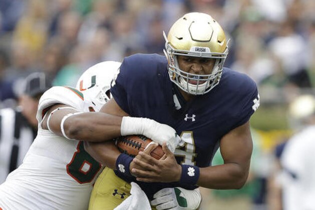 Notre Dame quarterback DeShone Kizer (14) is tackled by Miami 's RJ McIntosh during the first half of an NCAA college football game Saturday, Oct. 29, 2016, in South Bend, Ind. (AP Photo/Darron Cummings)