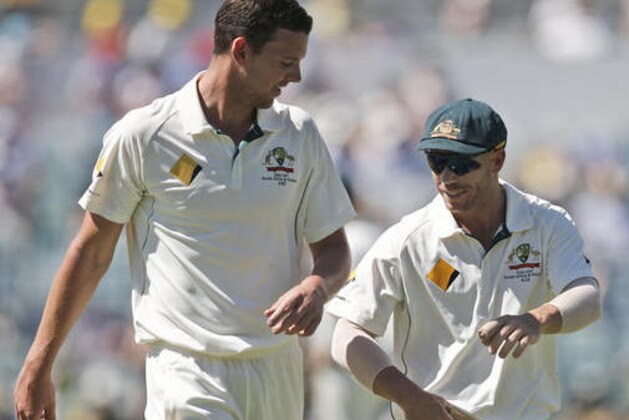 Australia's Josh Hazlewood, left, and David Warner chat on field on the third day of play during their cricket test match against South Africa in Perth, Australia, Saturday, Nov. 5, 2016. (AP Photo/Rob Griffith)
