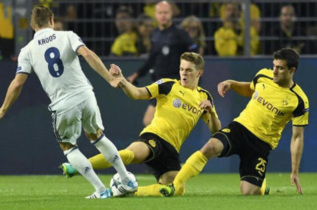 Real Madrid's Toni Kroos, left, is challenged by Dortmund's Matthias Ginter, center, and Sokratis Papastathopoulos, right, during the Champions League group F soccer match between Borussia Dortmund and Real Madrid in Dortmund, Germany, Tuesday, Sept. 27, 2016. (AP Photo/Martin Meissner)