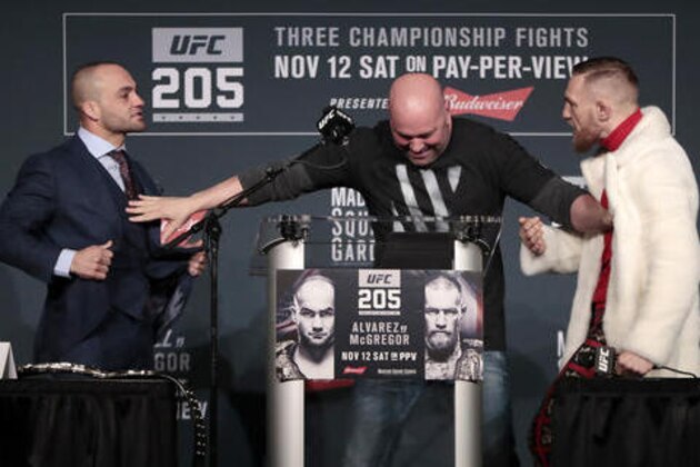 UFC president Dana White, center, stands between fighters Eddie Alvarez, left, and Conor McGregor during a news conference ahead of the UFC 205 mixed martial arts fights, Thursday, Nov. 10, 2016, at Madison Square Garden in New York. McGregor and Alvarez will fight each other on Saturday. (AP Photo/Julio Cortez)