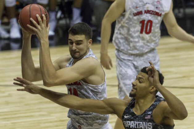 Arizona center Dusan Ristic, left, grabs a rebound from Michigan State forward Kenny Goins, right, in the first half of an NCAA college basketball game at the Armed Forces Classic, Friday, Nov. 11, 2016, in Honolulu. (AP Photo/Eugene Tanner)