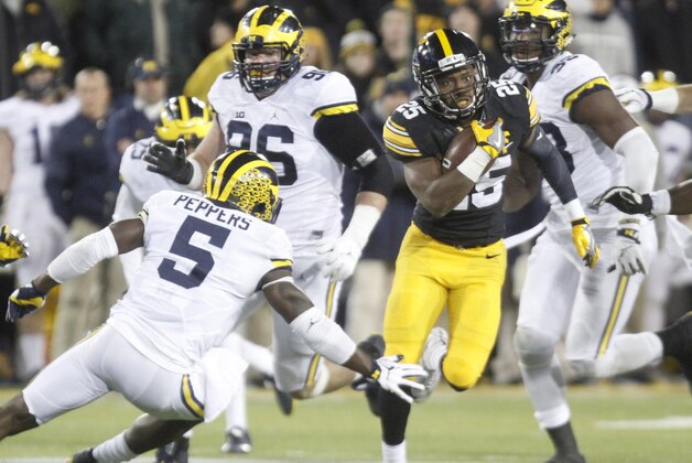 IOWA CITY, IOWA- NOVEMBER 12:  Running back Akrum Wadley #25 of the Iowa Hawkeyes rushes up the field in front of linebacker Jabrill Peppers #5 of the Michigan Wolverines during the third quarter on November 12, 2016 at Kinnick Stadium in Iowa City, Iowa.  (Photo by Matthew Holst/Getty Images)