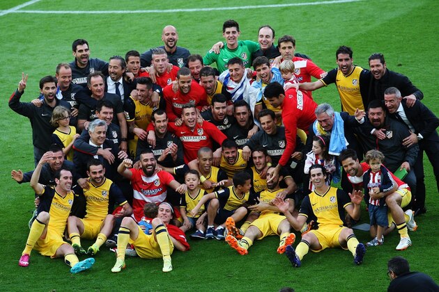 Atletico de Madrid's football players and staff pose as they celebrate their Spanish league title at the end of the Spanish league football match FC Barcelona vs Club Atletico de Madrid at the Camp Nou stadium in Barcelona on May 17, 2014. Atletico Madrid claimed their 10th Spanish league crown today but first in 18 years after coming from behind to draw 1-1 away at title rivals Barcelona.    AFP PHOTO/ QUIQUE GARCIA        (Photo credit should read QUIQUE GARCIA/AFP/Getty Images)
