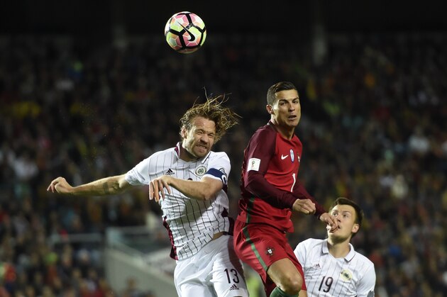 Latvia's defender Kaspars Gorkss (L) vies with Portugal's forward Cristiano Ronaldo during the WC 2018 qualifying football match Portugal vs Latvia at the Algarve stadium in Faro on November 13, 2016. / AFP / FRANCISCO LEONG        (Photo credit should read FRANCISCO LEONG/AFP/Getty Images)