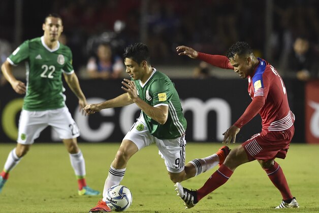 Mexico's Raul Jimenez (C) is marked by Panama's Amilcar Henriquez (R) during their 2018 FIFA World Cup qualifier football match in Panama City on November 15, 2016. / AFP / RODRIGO ARANGUA        (Photo credit should read RODRIGO ARANGUA/AFP/Getty Images)