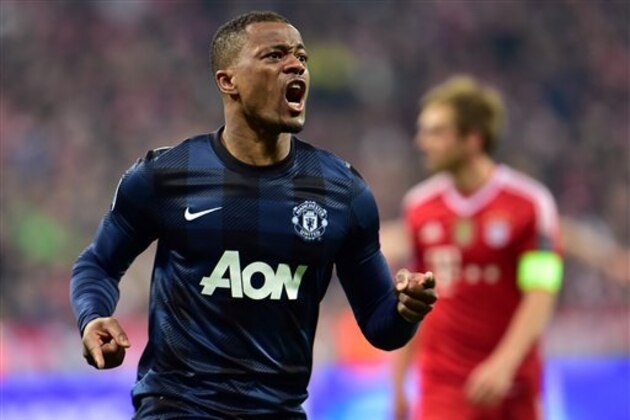 Manchester United's Patrice Evra, left, celebrates his side's opening goal during the Champions League quarterfinal second leg soccer match between Bayern Munich and Manchester United in the Allianz Arena in Munich, Germany, Wednesday, April 9, 2014. At right is Bayern's Philipp Lahm. (AP Photo/Kerstin Joensson)
