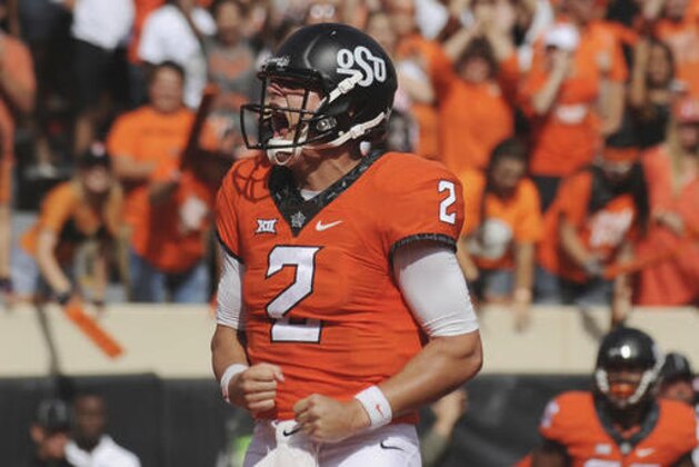 FILE - In this Oct. 29, 2016, file photo, Oklahoma State quarterback Mason Rudolph screams after scoring a touchdown in the third quarter of an NCAA college football game against West Virginia, in Stillwater, Okla. After escaping with a 45-44 victory over Texas Tech on Saturday, No. 13 Oklahoma State needs to win next week against TCU to set up a showdown with No. 8 Oklahoma on Dec. 3 for the Big 12 championship, with a chance at the College Football Playoff still a long shot. (AP Photo/Brody Schmidt, File)
