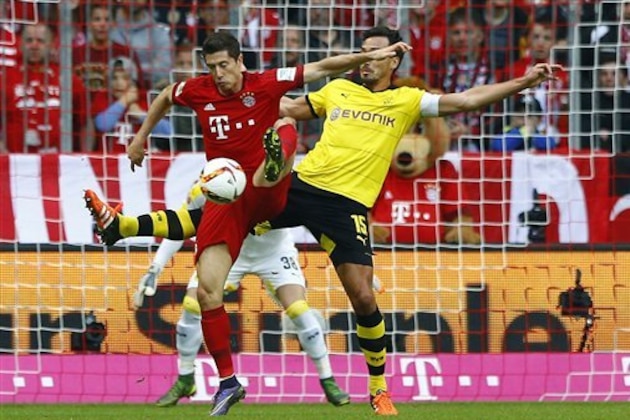 Bayern's Robert Lewandowski, left, and Dortmund's Mats Hummels challenge for the ball during the German Bundesliga soccer match between FC Bayern Munich and Borussia Dortmund at the Allianz Arena stadium in Munich, Germany, Sunday, Oct. 4, 2015. (AP Photo/Matthias Schrader)