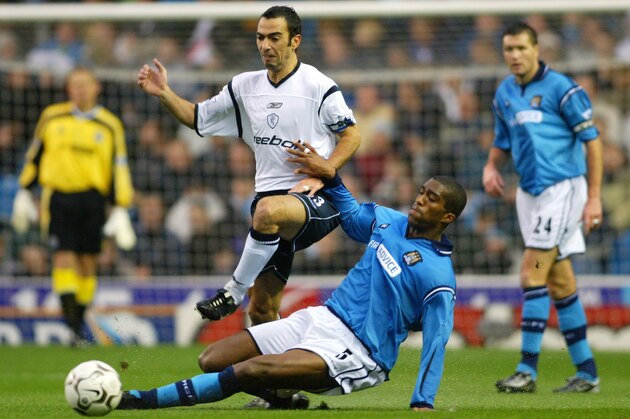 MANCHESTER - NOVEMBER 30:  Youri Djorkaeff of Bolton Wanderers takes the ball past Sylvain Distin of Manchester City during the FA Barclaycard Premiership match held on November 30, 2002 at Maine Road, in Manchester, England. Manchester City won the match 2-0. (Photo by Laurence Griffiths/Getty Images)