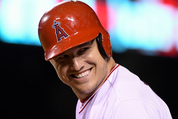 Sep 12, 2016; Anaheim, CA, USA;  Los Angeles Angels center fielder Mike Trout (27) smiles a he turns around 1st base after singling in the 8th inning against the Seattle Mariners at Angel Stadium of Anaheim. Mandatory Credit: Robert Hanashiro-USA TODAY Sports