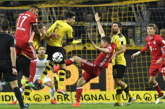 Bayern's Robert Lewandowski, center, challenges for the ball with Dortmund's Marc Bartra, center top, during the German Bundesliga soccer match between Borussia Dortmund and Bayern Munich in Dortmund, Germany, Saturday, Nov. 19, 2016. (AP Photo/Martin Meissner)