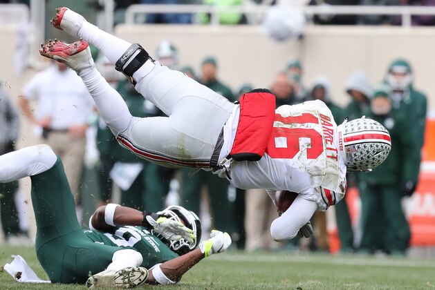 EAST LANSING, MI - NOVEMBER 19: J.T. Barrett #16 of the Ohio State Buckeye leaps over Montae Nicholson #9 of the Michigan State Spartans for a short gain during the second quarter of the game sat Spartan Stadium on November 19, 2016 in East Lansing, Michigan. (Photo by Leon Halip/Getty Images)