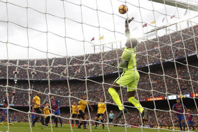 Malaga's goalkeeper Carlos Kameni, right, saves a ball during the Spanish La Liga soccer match between FC Barcelona and Malaga at the Camp Nou in Barcelona, Spain, Saturday, Nov. 19, 2016. (AP Photo/Manu Fernandez)