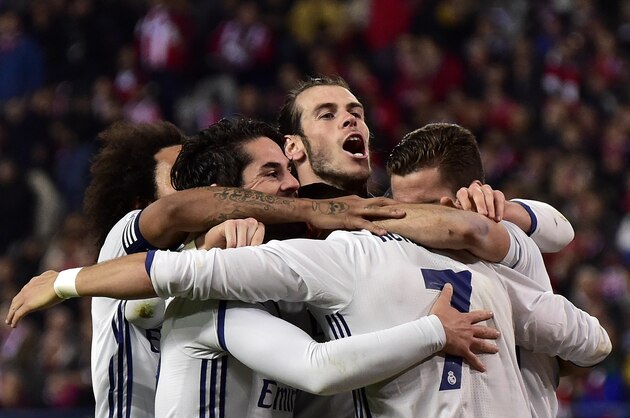 Real Madrid's Portuguese forward Cristiano Ronaldo (back) is congratulated by teammates after his hat-trick during the Spanish league football match between Club Atletico de Madrid and Real Madrid CF at the Vicente Calderon stadium in Madrid, on November 19, 2016. / AFP / GERARD JULIEN        (Photo credit should read GERARD JULIEN/AFP/Getty Images)