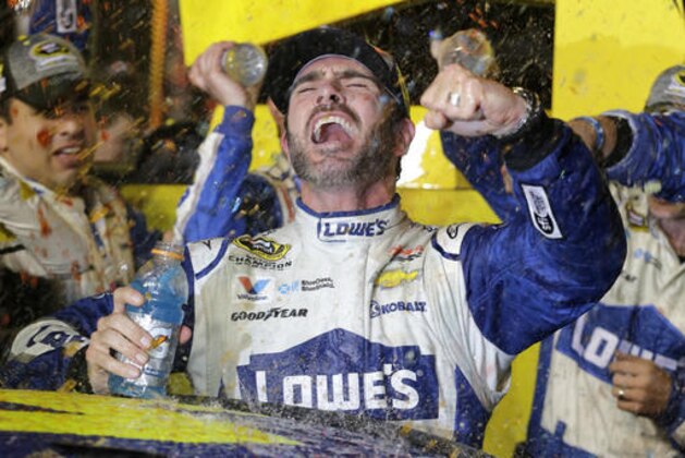 Jimmie Johnson celebrates his NASCAR Sprint Cup auto race and season title win Sunday, Nov. 20, 2016, in Homestead, Fla. (AP Photo/Terry Renna)