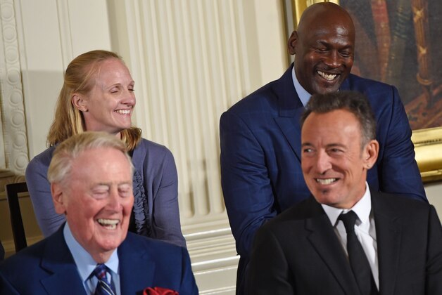 NBA star Michael Jordan (R top) and  rock icon Bruce Springsteen (R) laugh along with some of the other 21 recipients of the Presidential Medal of Freedom as US President Barack Obama speaks before presenting the nation's highest civilian honor, during a ceremony in the East Room of the White House in Washington, DC, November 22, 2016. / AFP / SAUL LOEB        (Photo credit should read SAUL LOEB/AFP/Getty Images)