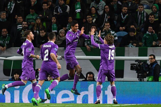 Real Madrid's defender Raphael Varane (3L) celebrates after scoring the opening goal during the UEFA Champions League football match Sporting CP vs Real Madrid CF at the Jose Alvalade stadium in Lisbon on November 22, 2016. / AFP / FRANCISCO LEONG        (Photo credit should read FRANCISCO LEONG/AFP/Getty Images)