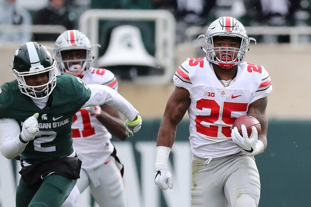 EAST LANSING, MI - NOVEMBER 19: Mike Weber #25 of the Ohio State Buckeyes runs for a long run as Montae Nicholson #9 of the Michigan State Spartans makes the stop during the third quarter of the game at Spartan Stadium on November 19, 2016 in East Lansing, Michigan. Ohio State defeated Michigan State 17-16. (Photo by Leon Halip/Getty Images)