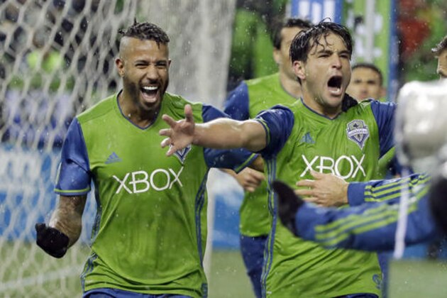 Seattle Sounders forward Nicolas Lodeiro, right, celebrates with defender Tyrone Mears, left, after Lodeiro scored a goal against the Colorado Rapids in the second half of the first leg of the MLS soccer Western Conference championship, Tuesday, Nov. 22, 2016, in Seattle. The Sounders beat the Rapids 2-1.(AP Photo/Ted S. Warren)