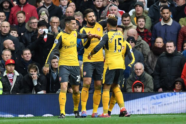 Arsenal's French striker Olivier Giroud (2L) celebrates scoring his team's first goal with Arsenal's English midfielder Alex Oxlade-Chamberlain (2R), Arsenal's Chilean striker Alexis Sanchez (R) and Arsenal's Swiss midfielder Granit Xhaka during the English Premier League football match between Manchester United and Arsenal at Old Trafford in Manchester, north west England, on November 19, 2016. / AFP / Paul ELLIS / RESTRICTED TO EDITORIAL USE. No use with unauthorized audio, video, data, fixture lists, club/league logos or 'live' services. Online in-match use limited to 75 images, no video emulation. No use in betting, games or single club/league/player publications.  /         (Photo credit should read PAUL ELLIS/AFP/Getty Images)