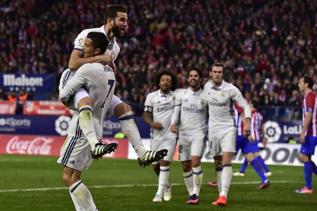 Real Madrid's Portuguese forward Cristiano Ronaldo (L bottom) celebrates with Real Madrid's defender Nacho Fernandez after scoring a third goal during the Spanish league football match between Club Atletico de Madrid and Real Madrid CF at the Vicente Calderon stadium in Madrid, on November 19, 2016. / AFP / GERARD JULIEN        (Photo credit should read GERARD JULIEN/AFP/Getty Images)