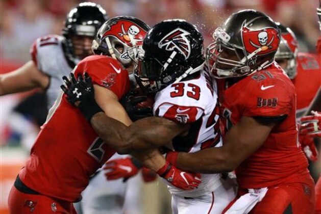 Tampa Bay Buccaneers safety Chris Conte (23) and linebacker Daryl Smith (51) tackle Atlanta Falcons running back Stevan Ridley (33) during an NFL football game Thursday, Nov. 3, 2016, in Tampa, Fla. (Jeff Haynes/AP Images for Panini)