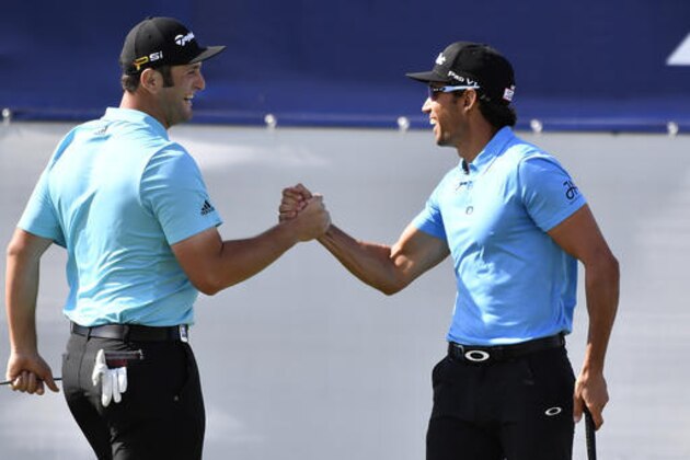Spain's Rafa Cabrera Bello, right, is congratulated by his partner Jon Rahm after sinking a birdie putt on the 18th green during his match at the World Cup of Golf at Kingston Heath in Melbourne, Australia, Thursday, Nov. 24, 2016. (AP Photo/Andrew Brownbill)