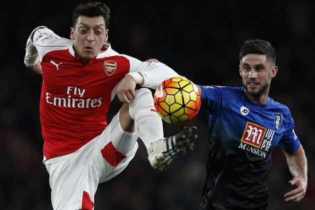 Arsenal's German midfielder Mesut Ozil controls the ball in front of Bournemouth's South African-born English midfielder Andrew Surman (R) during the English Premier League football match between Arsenal and Bournemouth at the Emirates Stadium in London on December 28, 2015. AFP PHOTO / ADRIAN DENNIS

RESTRICTED TO EDITORIAL USE. No use with unauthorized audio, video, data, fixture lists, club/league logos or 'live' services. Online in-match use limited to 75 images, no video emulation. No use in betting, games or single club/league/player publications. / AFP / ADRIAN DENNIS        (Photo credit should read ADRIAN DENNIS/AFP/Getty Images)