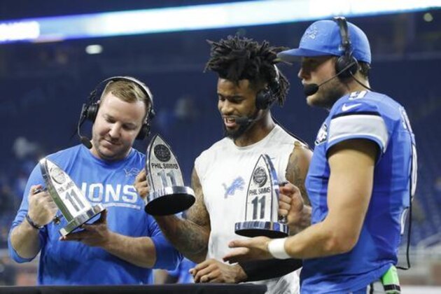 Detroit Lions kicker Matt Prater, left, cornerback Darius Slay, center, and quarterback Matthew Stafford are presented the Phil Simms All-Iron trophies after their 16-13 win over the Minnesota Vikings, Thursday, Nov. 24, 2016 in Detroit. (AP Photo/Paul Sancya)
