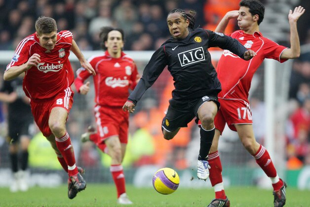 Manchester United's Brazilian midfielder Anderson (C) races through the challenges of Liverpool's English midfielder Steven Gerrard (L) and Spanish defender Alvaro Arbeloa during their English Premiership football match at Anfield, in Liverpool, north-west England, 16 December 2007. AFP PHOTO/ANDREW YATES - Mobile and website use of domestic English football pictures are subject to obtaining a Photographic End User Licence from Football DataCo Ltd Tel : +44 (0) 207 864 9121 or e-mail accreditations@football-dataco.com - applies to Premier and Football League matches. (Photo credit should read ANDREW YATES/AFP/Getty Images)