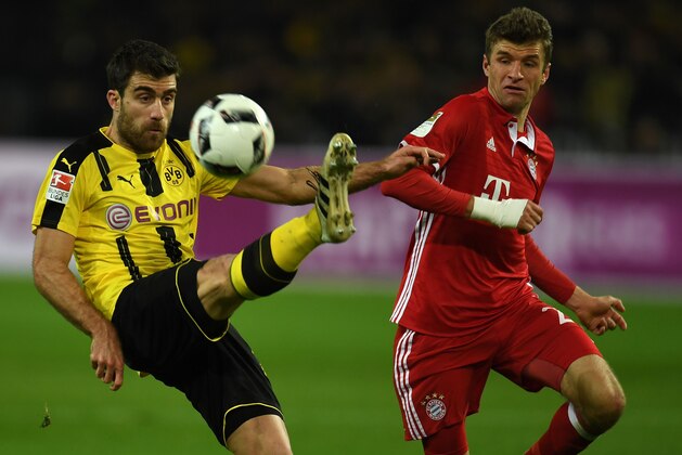 Bayern Munich's midfielder Thomas Mueller and Dortmund's Greek defender Sokratis vie for the ball during the German first division Bundesliga football match between Borussia Dortmund and FC Bayern Munich in Dortmund on November 19, 2016. / AFP / PATRIK STOLLARZ / RESTRICTIONS: DURING MATCH TIME: DFL RULES TO LIMIT THE ONLINE USAGE TO 15 PICTURES PER MATCH AND FORBID IMAGE SEQUENCES TO SIMULATE VIDEO. == RESTRICTED TO EDITORIAL USE == FOR FURTHER QUERIES PLEASE CONTACT DFL DIRECTLY AT + 49 69 650050
        (Photo credit should read PATRIK STOLLARZ/AFP/Getty Images)