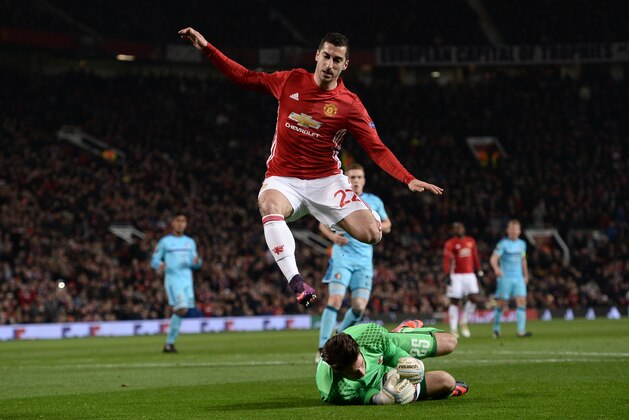 Feyenoord's Australian goalkeeper Brad Jones (floor) claims the ball ahead of Manchester United's Armenian midfielder Henrikh Mkhitaryan (top) during the UEFA Europa League group A football match between Manchester United and Feyenoord at Old Trafford stadium in Manchester, north-west England, on November 24, 2016. / AFP / Oli SCARFF        (Photo credit should read OLI SCARFF/AFP/Getty Images)