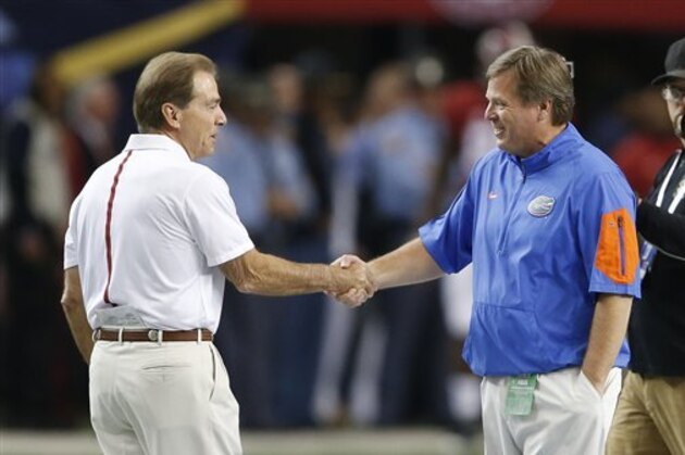 Alabama head coach Nick Saban, left, speaks with Florida head coach Jim McElwain the first half of the Southeastern Conference championship NCAA college football game, Saturday, Dec. 5, 2015, in Atlanta. (AP Photo/John Bazemore)