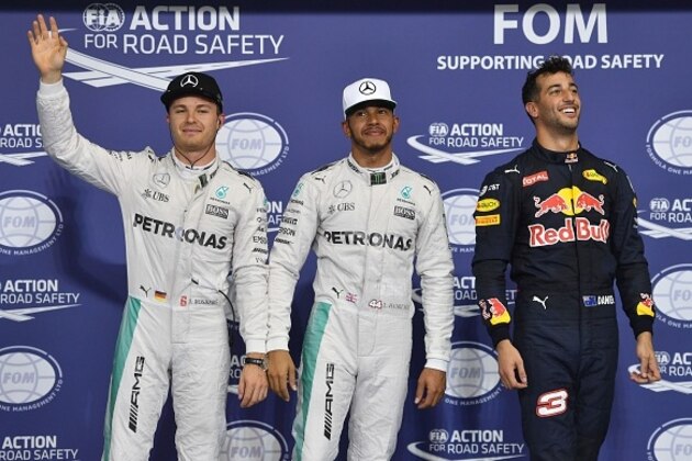 Mercedes AMG Petronas F1 Team's British driver Lewis Hamilton (C), flanked by his German teammate Nico Rosberg (L) and Infiniti Red Bull Racing's Australian driver Daniel Ricciardo, celebrate at the end of the qualifying session as part of the Abu Dhabi Formula One Grand Prix at the Yas Marina circuit on November 26, 2016.
Lewis Hamilton will start on pole for the Abu Dhabi Grand Prix title showdown after the defending champion bettered his Mercedes teammate Nico Rosberg in qualifying. Red Bull's Daniel Ricciardo came in third to start on the second row at Yas Marina where the Australian is joined by the Ferrari of Kimi Raikkonen. / AFP / Andrej ISAKOVIC        (Photo credit should read ANDREJ ISAKOVIC/AFP/Getty Images)