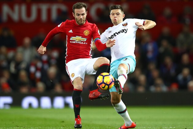 MANCHESTER, ENGLAND - NOVEMBER 27:  Aaron Cresswell of West Ham United (R) and Juan Mata of Manchester United (L) battle for possession during the Premier League match between Manchester United and West Ham United at Old Trafford on November 27, 2016 in Manchester, England.  (Photo by Clive Brunskill/Getty Images)