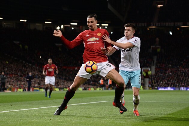 Manchester United's Swedish striker Zlatan Ibrahimovic (L) shields the ball from West Ham United's English defender Aaron Cresswell (R) during the English Premier League football match between Manchester United and West Ham United at Old Trafford in Manchester, north west England, on November 27, 2016. / AFP / Oli SCARFF / RESTRICTED TO EDITORIAL USE. No use with unauthorized audio, video, data, fixture lists, club/league logos or 'live' services. Online in-match use limited to 75 images, no video emulation. No use in betting, games or single club/league/player publications.  /         (Photo credit should read OLI SCARFF/AFP/Getty Images)