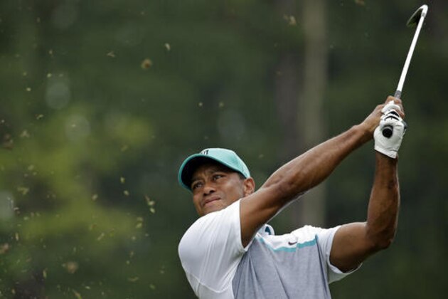 FILE - In this Aug. 20, 2015, file photo, Tiger Woods watches his shot on the 12th hole during the first round of the Wyndham Championship golf tournament in Greensboro, N.C. Woods says in a news release Tuesday, Nov. 1, 2016, he will be playing in his Hero World Challenge in the Bahamas the first week of December. (AP Photo/Chuck Burton, File)