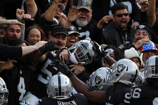 OAKLAND, CA - NOVEMBER 27:  Khalil Mack #52 of the Oakland Raiders celebrates in the stands after scoring on an interception of Cam Newton #1 of the Carolina Panthers in the second quarter of their NFL game on November 27, 2016 in Oakland, California.  (Photo by Thearon W. Henderson/Getty Images)