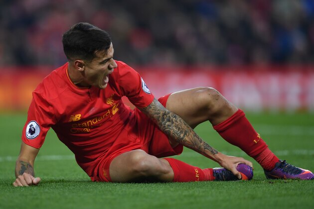 Liverpool's Brazilian midfielder Philippe Coutinho holds his foot as he lies on the pitch injured during the English Premier League football match between Liverpool and Sunderland at Anfield in Liverpool, north west England on November 26, 2016. / AFP / Paul ELLIS / RESTRICTED TO EDITORIAL USE. No use with unauthorized audio, video, data, fixture lists, club/league logos or 'live' services. Online in-match use limited to 75 images, no video emulation. No use in betting, games or single club/league/player publications.  /         (Photo credit should read PAUL ELLIS/AFP/Getty Images)