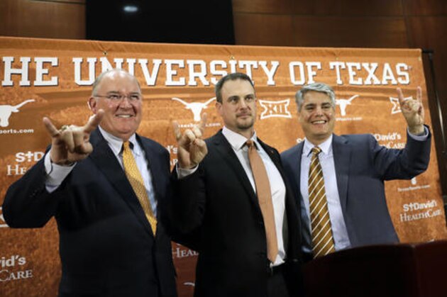 Tom Herman, center, poses with athletic director Mike Perrin, left, and school president Gregory Fenves, right, during a news conference where he was introduced at Texas' new head NCAA college football coach, Sunday, Nov. 27, 2016, in Austin. (AP Photo/Eric Gay)