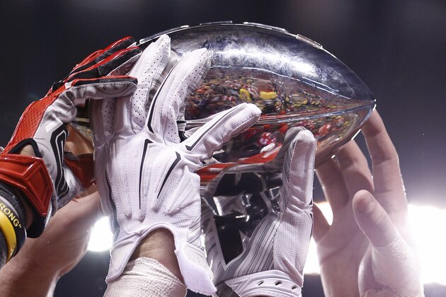 INDIANAPOLIS, IN - DECEMBER 6: Ohio State Buckeyes players hold up the championship trophy after the Big Ten Championship against the Wisconsin Badgers at Lucas Oil Stadium on December 6, 2014 in Indianapolis, Indiana. Ohio State defeated Wisconsin 59-0. (Photo by Joe Robbins/Getty Images)
