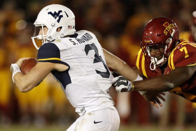 West Virginia quarterback Skyler Howard (3) runs from Iowa State defender Willie Harvey, right, during the second half of an NCAA college football game, Saturday, Nov. 26, 2016, in Ames, Iowa. (AP Photo/Charlie Neibergall)