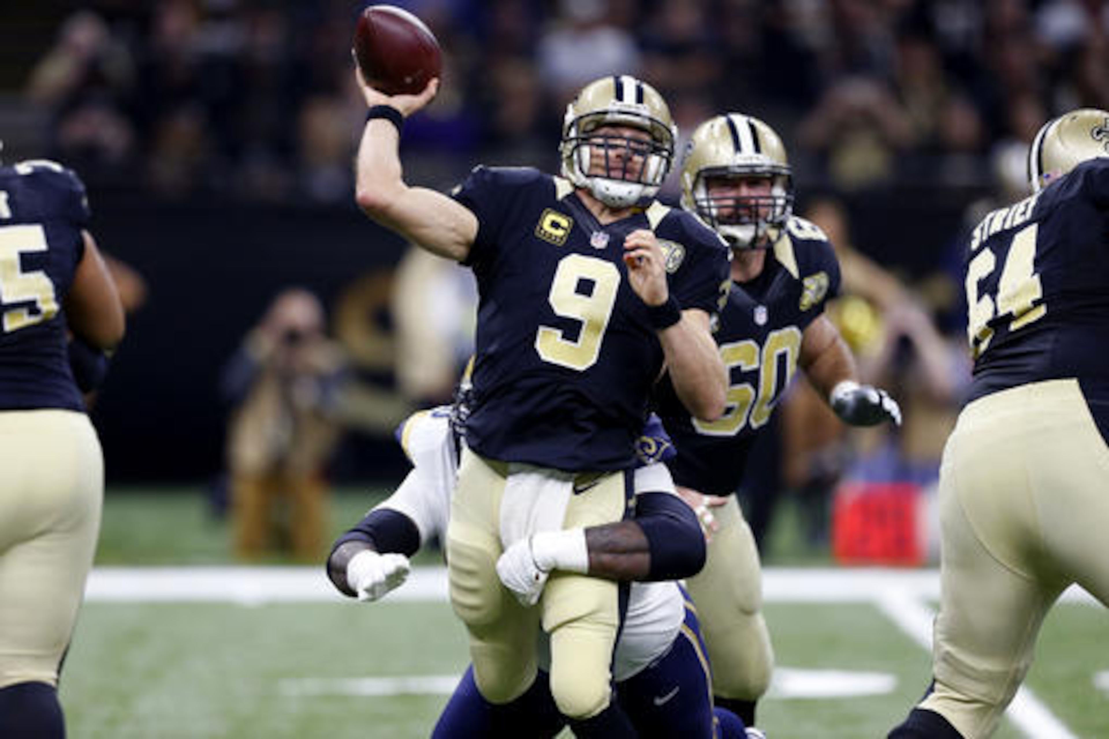 New Orleans Saints quarterback Drew Brees (9) passes under pressure from Los Angeles Rams defensive tackle Michael Brockers in the first half of an NFL football game in New Orleans, Sunday, Nov. 27, 2016. (AP Photo/Butch Dill)