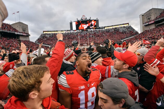 COLUMBUS, OH - NOVEMBER 26:  Jonathon Cooper #18 of the Ohio State Buckeyes celebrates with fans after defeating the Michigan Wolverines at Ohio Stadium on November 26, 2016 in Columbus, Ohio. Ohio State defeated Michigan 30-27 in two overtimes.  (Photo by Jamie Sabau/Getty Images)