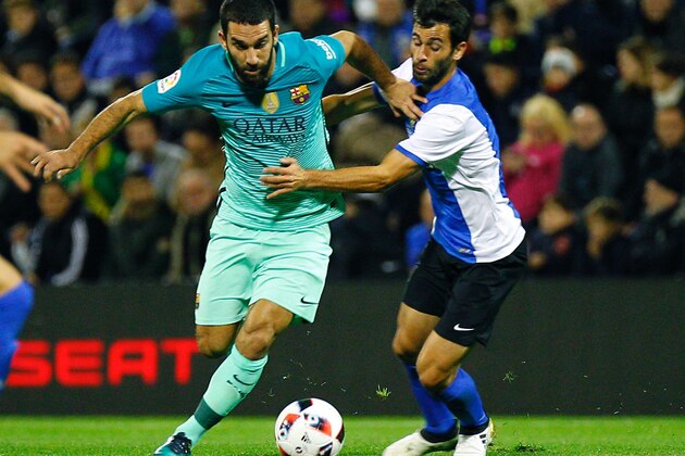 Barcelona's Turkish forward Arda Turan (L) vies with Hercules' midfielder Jose Manuel Gaspar during the Spanish Copa del Rey (King's Cup) round of 32 first leg football match Hercules CF vs FC Barcelona at the Estadio Jose Rico Perez in Alicante on November 30, 2016. / AFP / JOSE JORDAN        (Photo credit should read JOSE JORDAN/AFP/Getty Images)