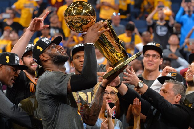 OAKLAND, CA - JUNE 19:  LeBron James #23 of the Cleveland Cavaliers gets ready to handle the NBA championship trophy against the Golden State Warriors during the 2016 NBA Finals Game Seven on June 19, 2016 at ORACLE Arena in Oakland, California. NOTE TO USER: User expressly acknowledges and agrees that, by downloading and or using this photograph, User is consenting to the terms and conditions of the Getty Images License Agreement. Mandatory Copyright Notice: Copyright 2016 NBAE (Photo by Jesse D. Garrabrant/NBAE via Getty Images)