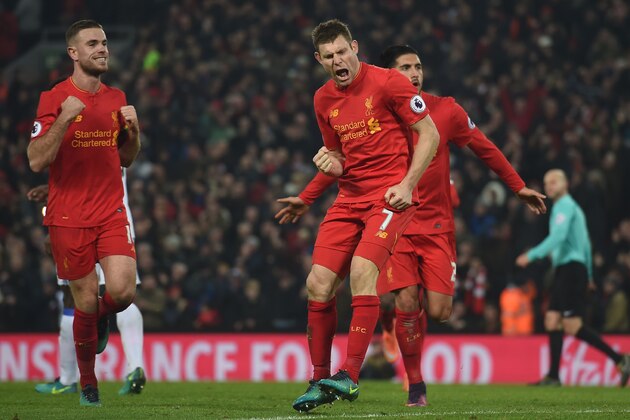 Liverpool's English midfielder James Milner (C) celebrates after scoring their second goal from the penalty spot with Liverpool's English midfielder Jordan Henderson (L) and Liverpool's German midfielder Emre Can (R) during the English Premier League football match between Liverpool and Sunderland at Anfield in Liverpool, north west England on November 26, 2016. / AFP / Paul ELLIS / RESTRICTED TO EDITORIAL USE. No use with unauthorized audio, video, data, fixture lists, club/league logos or 'live' services. Online in-match use limited to 75 images, no video emulation. No use in betting, games or single club/league/player publications.  /         (Photo credit should read PAUL ELLIS/AFP/Getty Images)